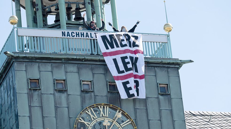 Der Wind hat etwas am Plakat der Demonstrierenden gezerrt, daher war der Schriftzug „Merz leck Eier“ nicht immer zu sehen. Foto: Klaus Ortgies