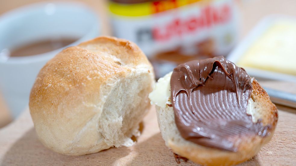 Ein Brötchen mit Nutella liegt auf einem Frühstücksbrett. Symbolfoto: Hendrik Schmidt/DPA/Archiv