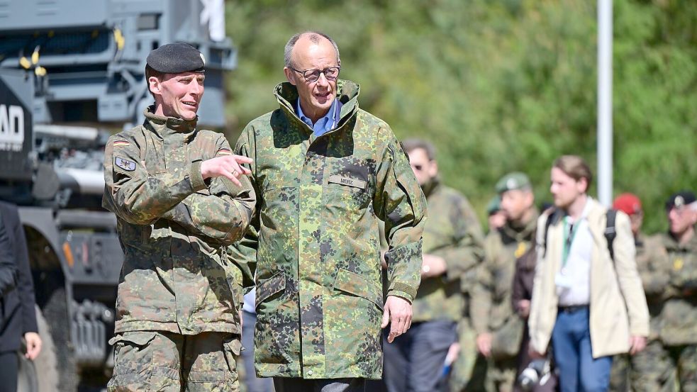 Merz (r) lässt sich vom Inspekteur des Heeres, Generalleutnant Christian Freuding, informieren. Foto: Philipp Schulze/dpa