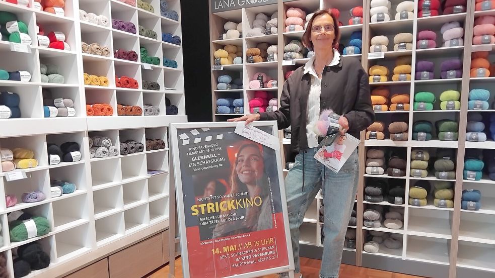 Ulla de Wall am Werbeschild für die Aktion: Der Kartenvorverkauf für das Strickkino in Papenburg läuft bereits. Foto: Clarissa Scherzer