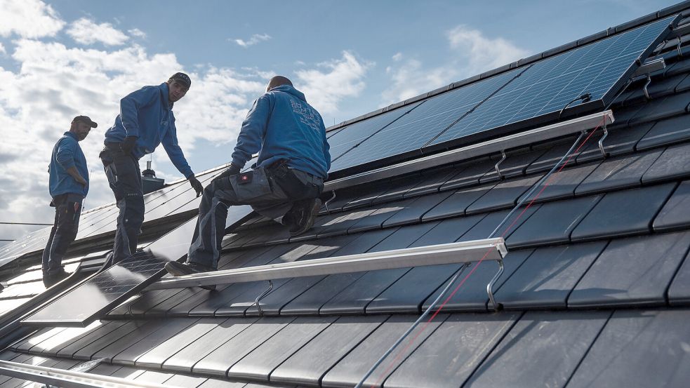 Mitarbeiter einer Solar-Firma montieren Photovoltaikmodule auf dem Dach eines Wohnhauses. Oft kommt die Steuerungstechnik von PV-Anlagen aus China. Foto: Marijan Murat/dpa