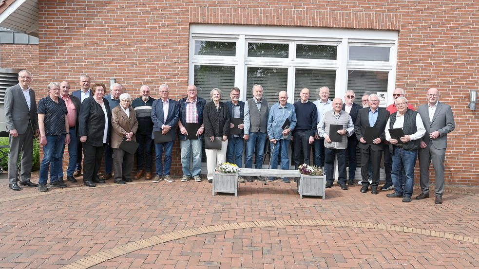 Die Volksbank Westrhauderfehn ehrte im Rahmen einer kleinen Feierstunde 19 Einzelpersonen und einen Verein für langjährige Mitgliedschaft. Das Foto zeigt die Geehrten mit den Vertretern der Volksbank. Foto: Holger Weers