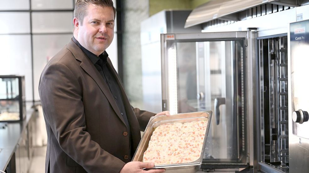 Firmenchef Jan-Peer Laabs hält im Betriebsrestaurant der Apetito-Zentrale eine Schale mit Lachs-Auflauf in der Hand. Foto: Wolf von Dewitz/dpa