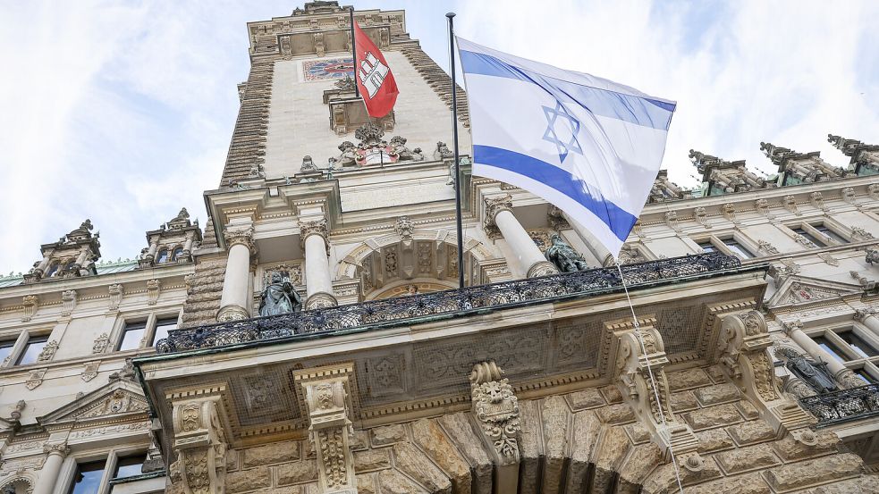 Am Hamburger Rathaus weht inzwischen eine Israel-Flagge. Am selben Ort wurde zuvor eine gleiche Flagge verbrannt. Foto: dpa/Christian Charisius