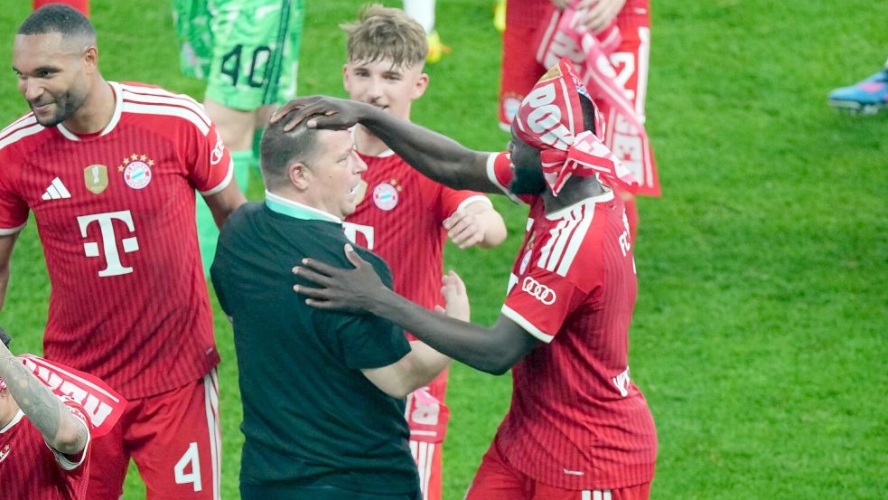 Max Eberl (M) feiert mit den Bayern-Spielern nach dem Münchner Finalsieg auf dem Platz. Foto: Soeren Stache/dpa