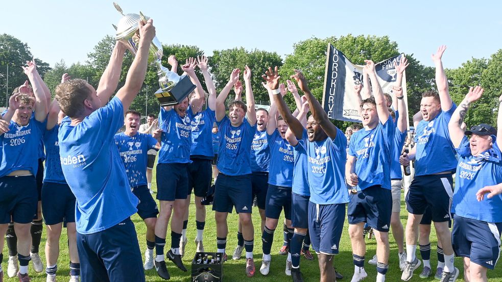 Voller Stolz präsentiert Ramslohs Mannschaftskapitän Jannis Heyens den Mitspielern und dem Betreuerteam den Kreispokal und reckt ihn in die Höhe. Foto: Holger Weers