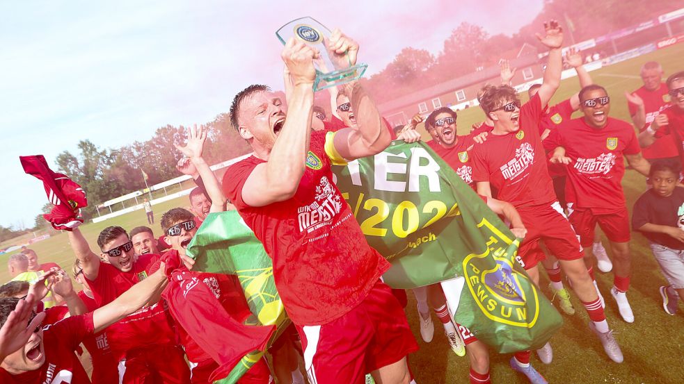 TuS-Kapitän Malte Risto reckt die Meister-Trophäe in die Höhe. Fotos: Jens Doden, Emden