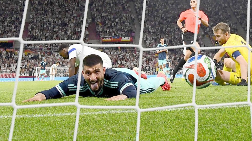 Ball rein, Zunge raus: Deniz Undav jubelt bäuchlings über sein zweites Tor gegen Finnland. Foto: Tom Weller/dpa