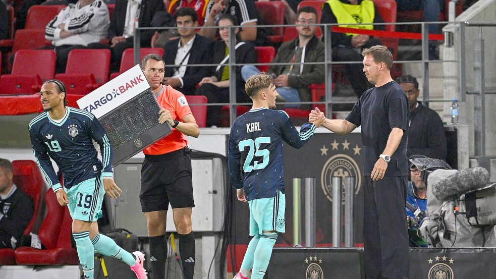Bundestrainer Nagelsmann (r) klatscht mit Lennart Karl ab. Startet der Bayern-Youngster bei der WM richtig durch? Foto: Tom Weller/dpa