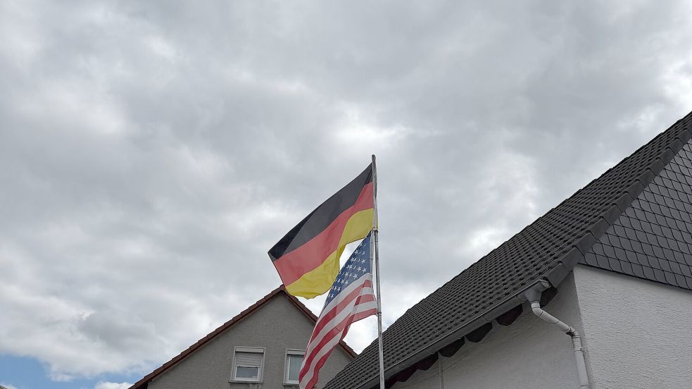 Die deutsche und die amerikanische Flagge wehen vor einem Haus in Ramstein. Foto: Carlotta Vorbrüggen