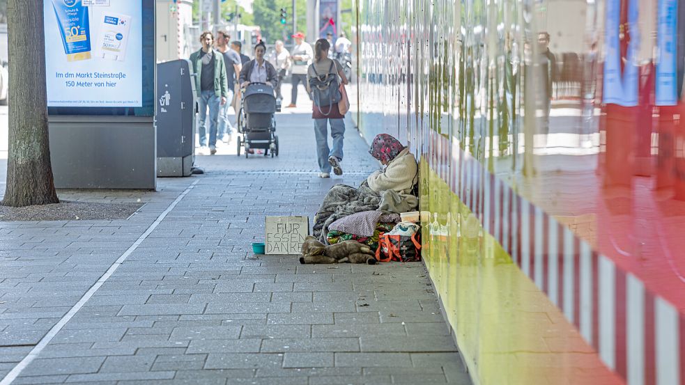 Eine Frau bettelt auf der Hamburger Mönckebergstrasse. Foto: dpa/Markus Scholz