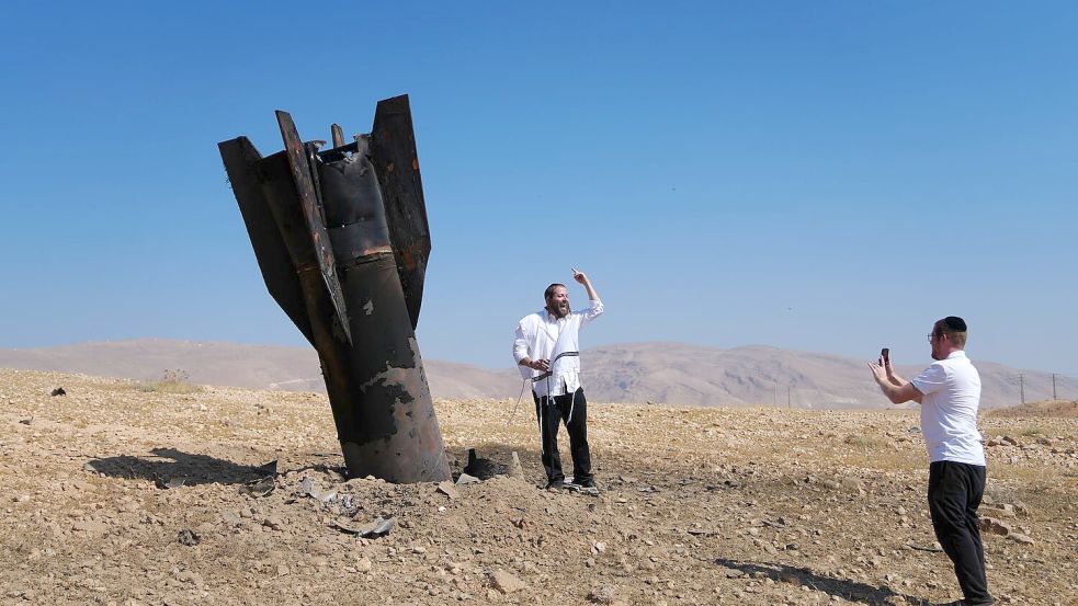 Menschen neben dem Wrack einer iranischen Rakete, die im Westjordanland eingeschlagen ist. Foto: Mahmoud Illean
