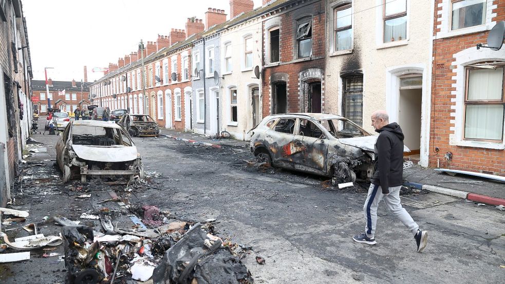 Nach Krawallen in Belfast blickt ein Mann in Belfast auf ausgebrannte Häuser und Unrat. Foto: dpa/AP|Peter Morrison