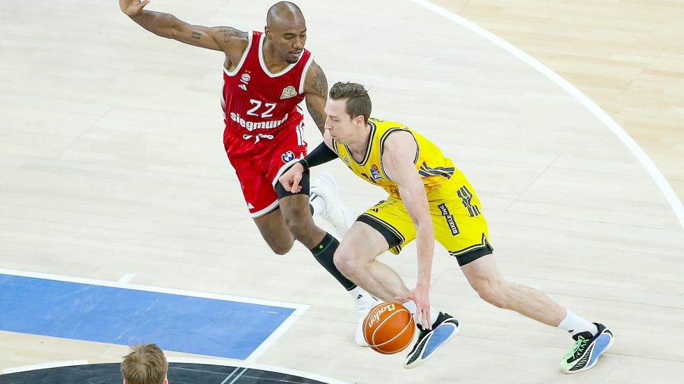 Bayerns Isiaha Mike (links) und Justin Bean von Alba Berlin kämpfen um den Ball. Foto: Matthias Stickel