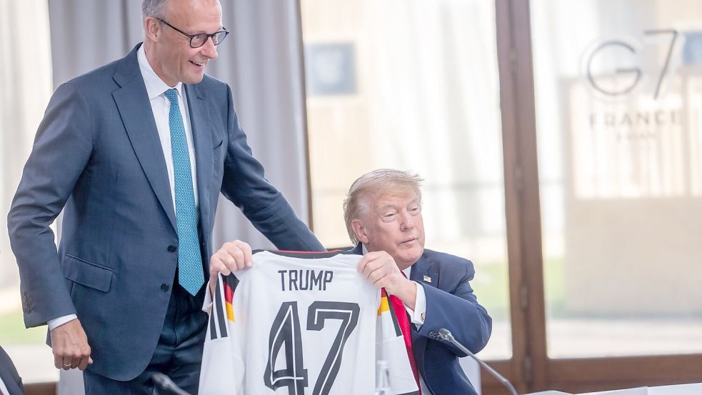 So richtig happy ist Trump mit seinem Geschenk offensichtlich nicht. Foto: Michael Kappeler/dpa-Pool/dpa