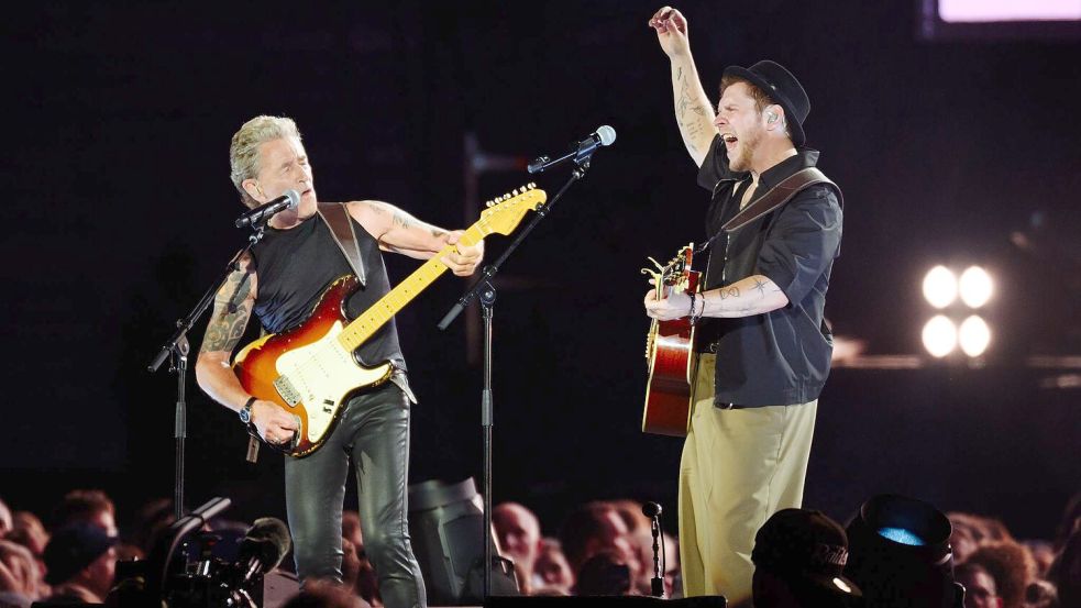 Maffay (l-r) und Oerding spielen gemeinsam auf der Bühne im Hamburger Volksparkstadion. Foto: Gregor Fischer