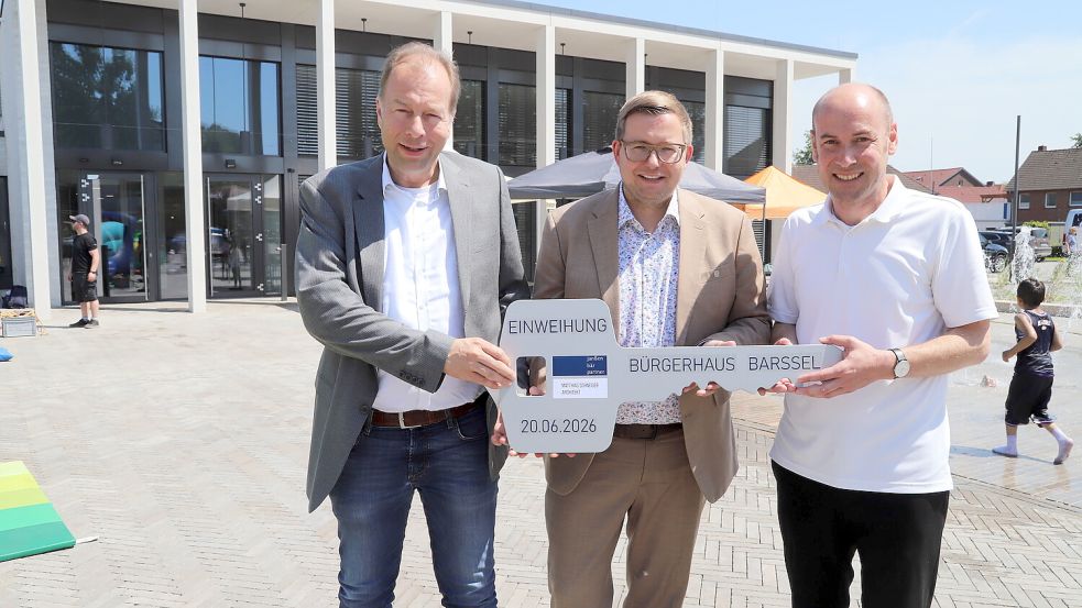 Zur Einweihung des neuen Bürgerhauses in Barßel übergaben die Architekten Christian Bär (links) und Matthias Schneider (rechts) symbolisch den Schlüssel an Bürgermeister Nils Anhuth (Mitte). Foto: Hans Passmann