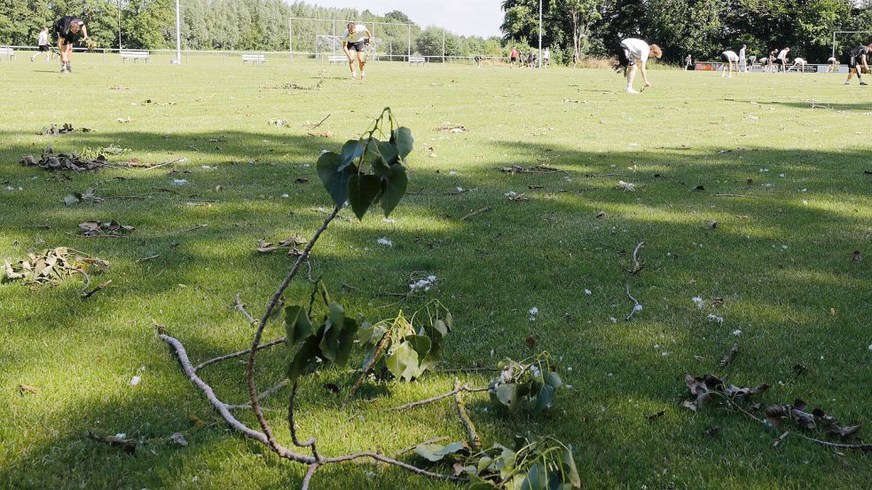 Vor dem Trainingsstart am Sonntag mussten die Fußballer des FC Loquard nach dem Gewittersturm in der Nacht zuvor den Platz von Ästen und Zweigen beseitigen. Foto: Poets