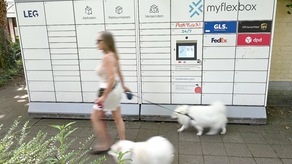 Gassigehen am Paketautomaten vorbei: Alltagsszene aus Düsseldorf. Foto: Wolf von Dewitz/dpa