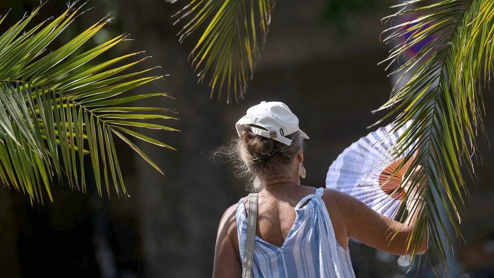 Ein Fächer, wie ihn hier eine Frau in Stuttgart bei sich trägt, ist derzeit ein gefragtes Sommer-Accessoire. Foto: Marijan Murat