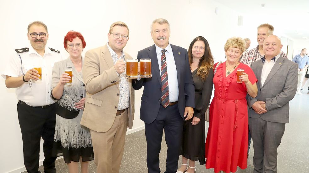 Stießen auf die 25-jährige Städtepartnerschaft mit einem Bier an: Bürgermeister Nils Anhuth (3. von links) und sein polnischer Kollege Zygmut Tucholski (4. von links) im Beisein der Delegation aus Elblag. Foto: Hans Passmann.