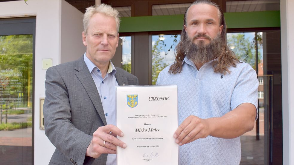 Anerkennung für Zivilcourage in Rhauderfehn: Bürgermeister Geert Müller (links) überreichte Mirko Malec eine Urkunde und dankte ihm für sein entschlossenes Eingreifen. Fotos: Henrik Zein