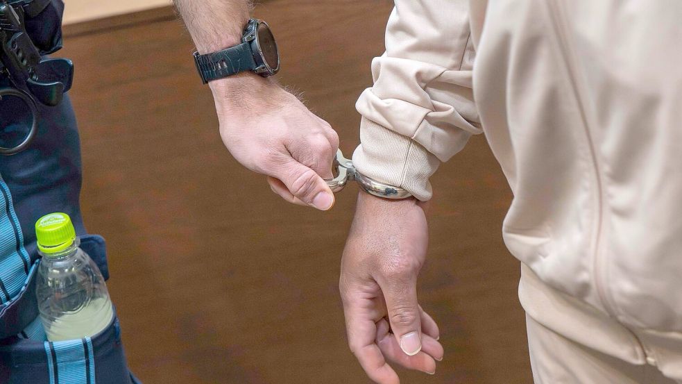 Einer der Angeklagten wird in den Gerichtssaal geführt - insgesamt sind zwölf Männer verurteilt worden. (Archivbild) Foto: Peter Kneffel/dpa