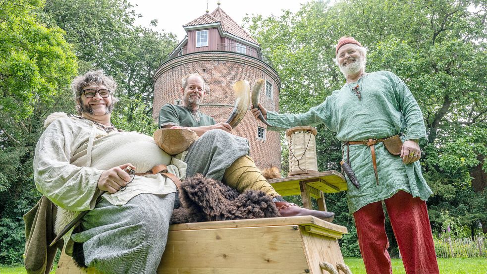 Sandro Cotterli (von links), Marten Hesse und Wolfgang Bergmann zeigen sich für das Foto vor der Burg Stickhausen in ihren Mittelalteroutfits. Foto: Klaus Ortgies