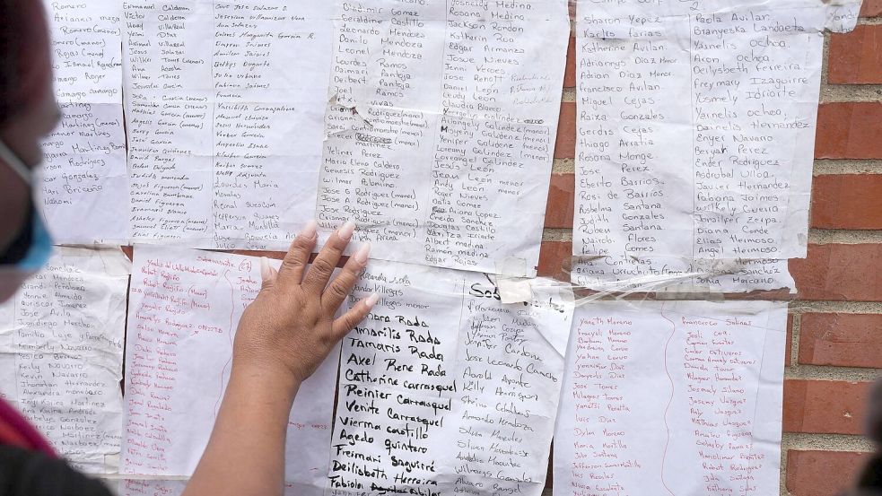 Menschen suchen nach den Namen von Angehörigen auf Listen überlebender Personen. Foto: Matias Delacroix