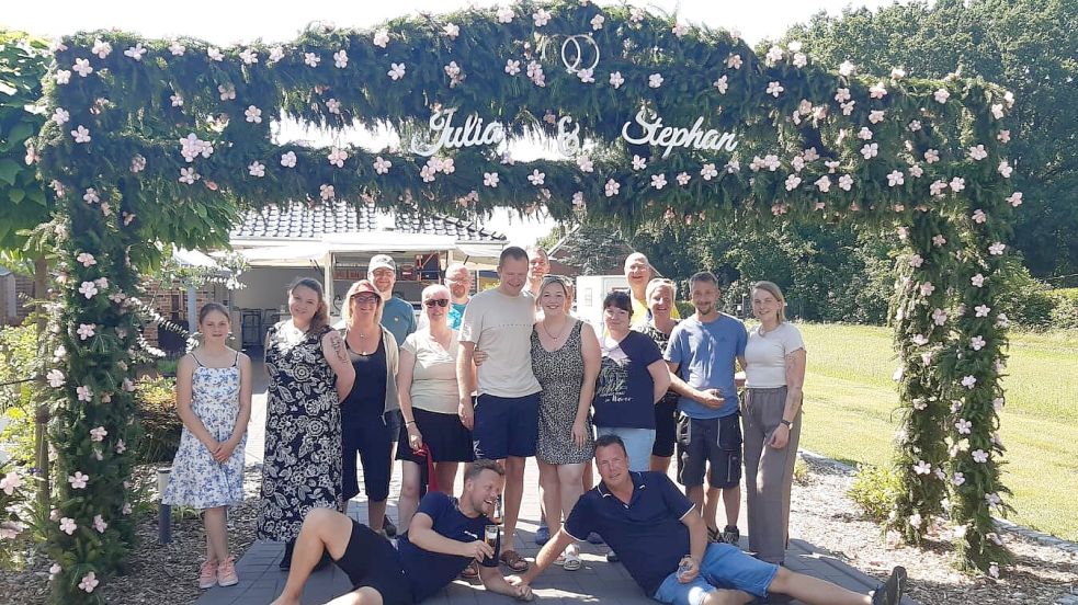 In der 1. Südwieke-Verlängerung in Rhauderfehn haben Nachbarn für Julia und Stephan Sterrenberg (Mitte) einen aufwendigen Hochzeitsbogen aufgestellt. Fotos: privat