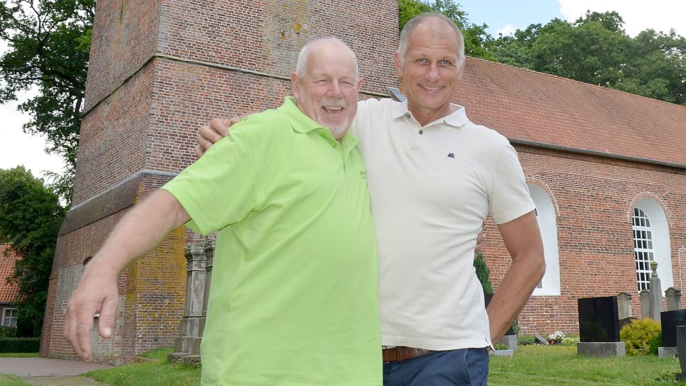 Seite an Seite stehen hier vor der St.-Laurentius-und-Vincentius-Kirche im Herzen Backemoors dessen Ortsbürgermeister Bernhard Bünnemeyer (links) und Arbeitskreisvorsitzender Torsten Bleeker. Gemeinsam freuen sich die Männer, dass Backemoor nun Gold-Dorf ist. Foto: Astrid Fertig