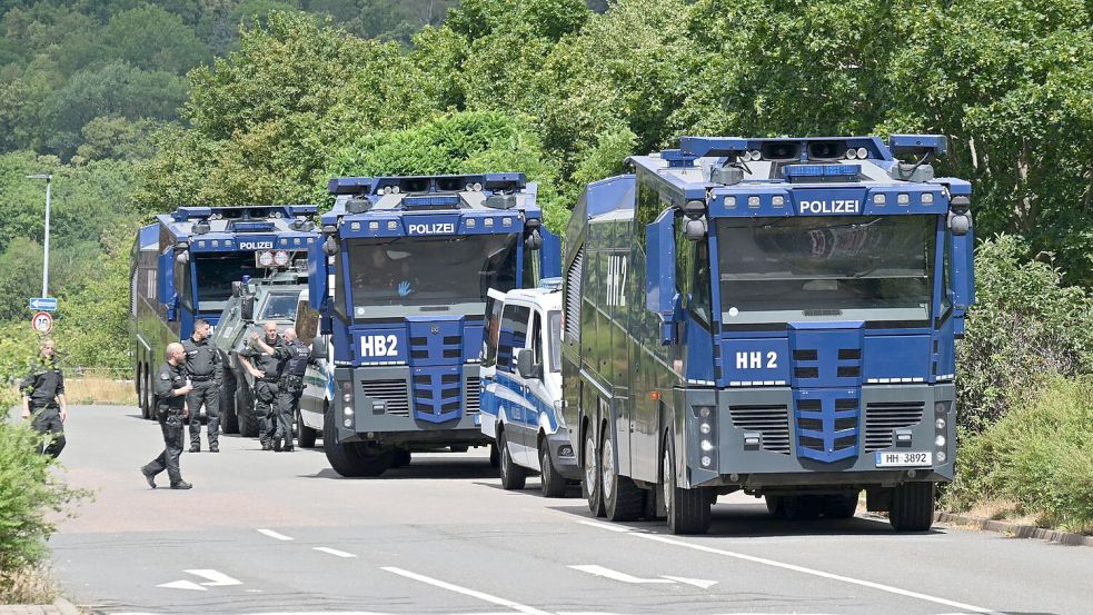 Wasserwerfer der Polizei stehen bereit, für den Fall, dass es zu Gewalt kommt. Foto: Martin Schutt/dpa