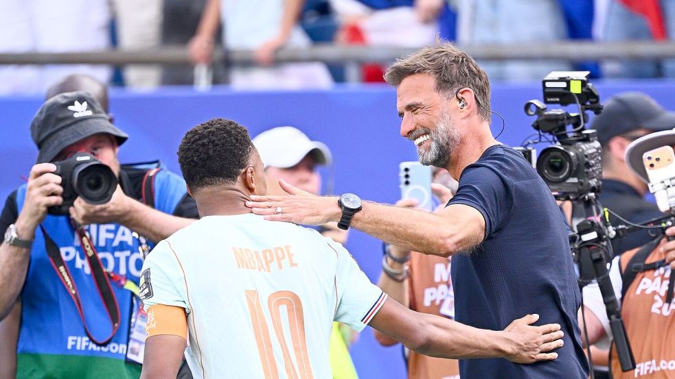 Kylian Mbappé (l.) und der designierte Bundestrainer Jürgen Klopp. Foto: Tom Weller/dpa