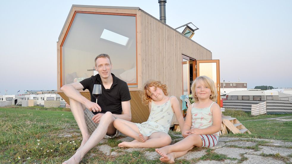 Tessa und Emilia (von rechts) genießen mit ihrem Papa Matthias den Sonnenuntergang vor einem Tiny House. Foto: Archiv/Ullrich