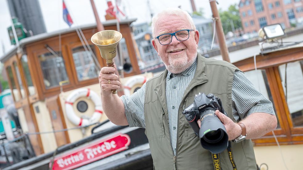 Bodo Wolters mit der Heroldglocke und seiner Kamera: Heute feiert er Geburtstag. Foto: Klaus Ortgies