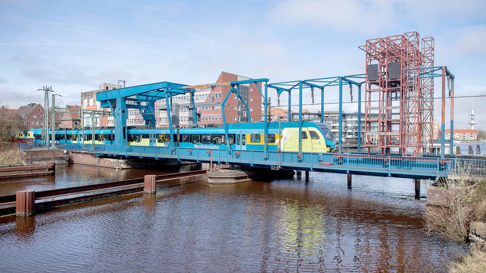 Ein Triebwagen der Westfalenbahn passiert die historische Eisenbahnklappbrücke im Hafen der Stadt. Foto: Hauke-Christian Dittrich/DPA