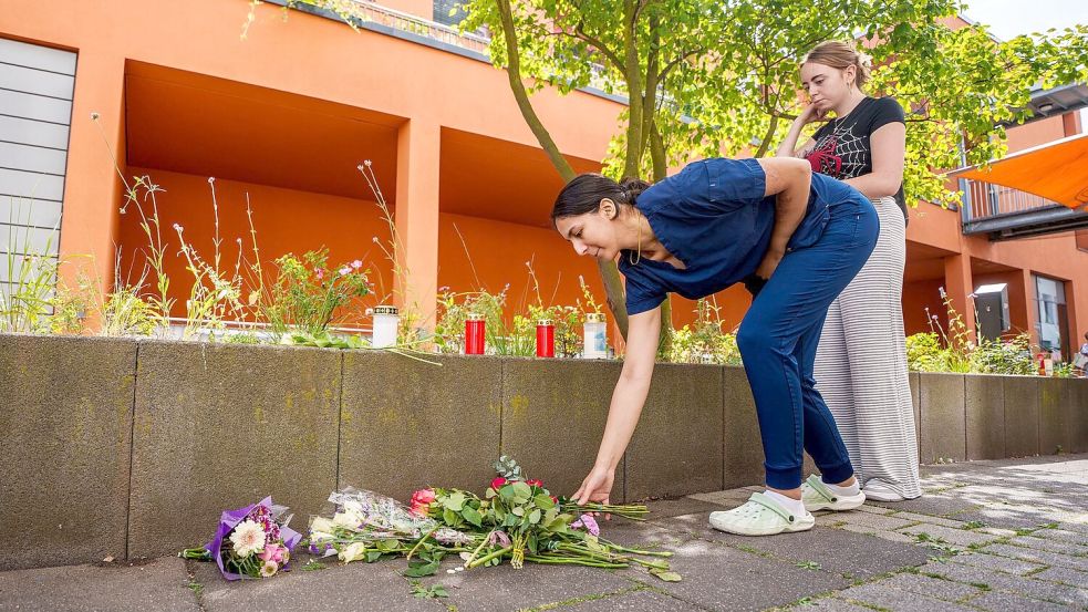 Menschen kommen vorbei und legen Blumen ab. Foto: Andreas Arnold