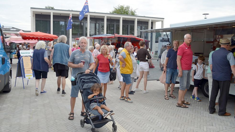 Karl-Heinz und Gunda Rasche aus Barßel-Neuland mit ihrem Enkel Jamil haben sich mit Kaffee und Fischbrötchen versorgt. Der Markt findet jetzt mit einem breiteren Angebot als vorher auf dem Rathausplatz statt. Foto: Astrid Fertig