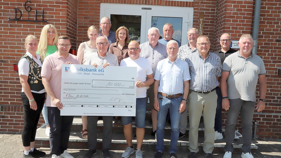 Bürgermeister Nils Anhuth (vorne, zweiter von links) hält den symbolischen Scheck über 10.000 Euro in Händen, den der Veranstalter des Riesenflohmarktes Claas Meyer (vierter von links) an das Flohmarktgremium mit Günter Ludmann (Mitte) übergab. Foto: Hans Passmann