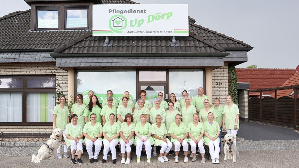 Das Foto zeigt einen Teil des Teams des Pflegedienstes „Up Dörp" mit den Team-Hunden Aranka und Hunor.