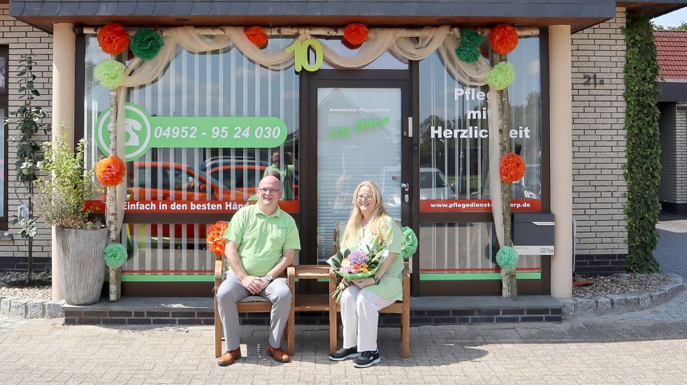 Jörg und Melanie Jelden sitzen unter dem Türkranz, den die Mitarbeiter und Mitarbeiterinnen zum Jubiläum aufgestellt haben.