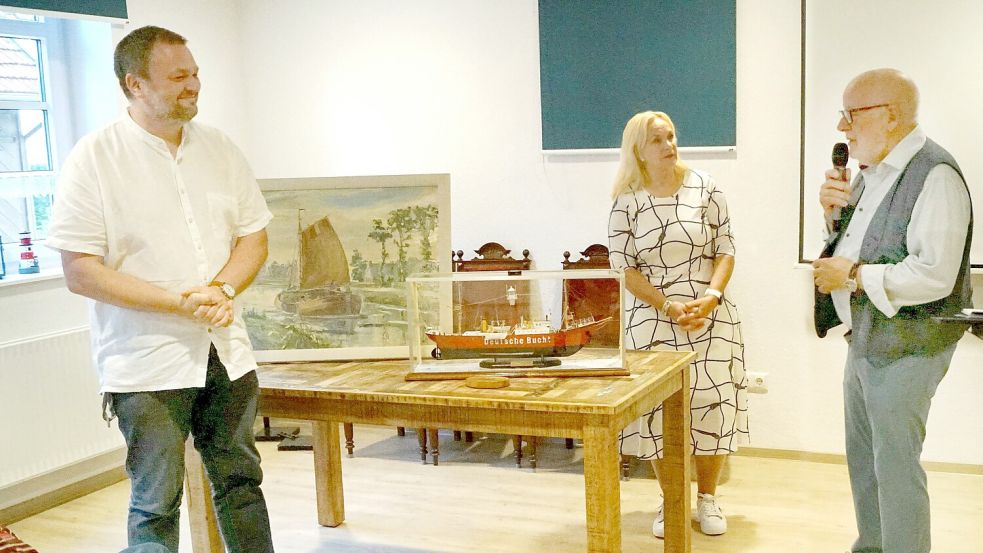 Marcus Neumann (links) und Jutta Kramer nehmen Gemälde und Modell von Heinz-Günther Buß in Empfang. Foto: privat