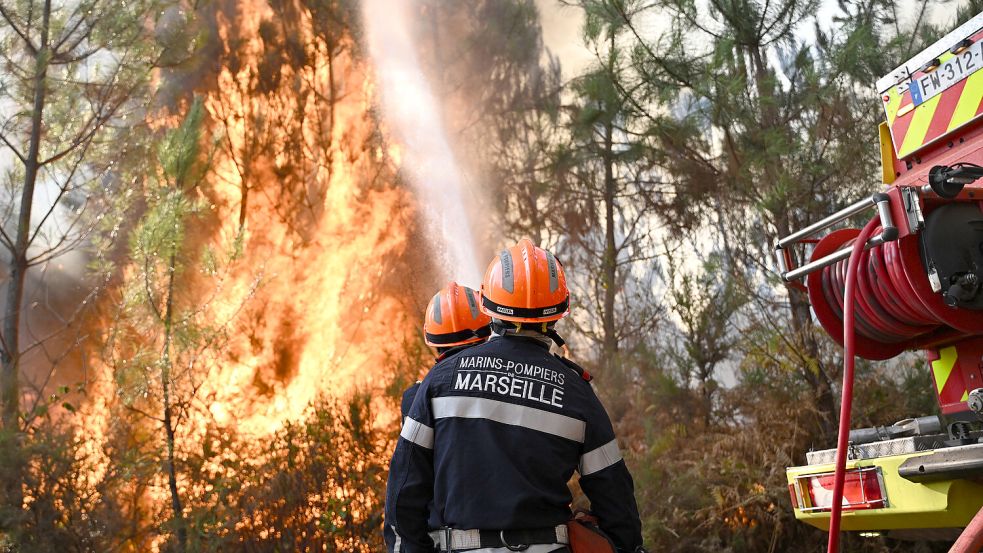 Feuerwehrleute bekämpfen einen Brand während der Waldbrände im Südwesten Frankreichs. Foto: Emma Da Silva/AP/dpa