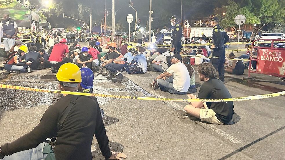 Menschen sitzen nach der Warnung wegen eines möglichen Nachbebens auf dem Boden. Foto: Philipp Znidar