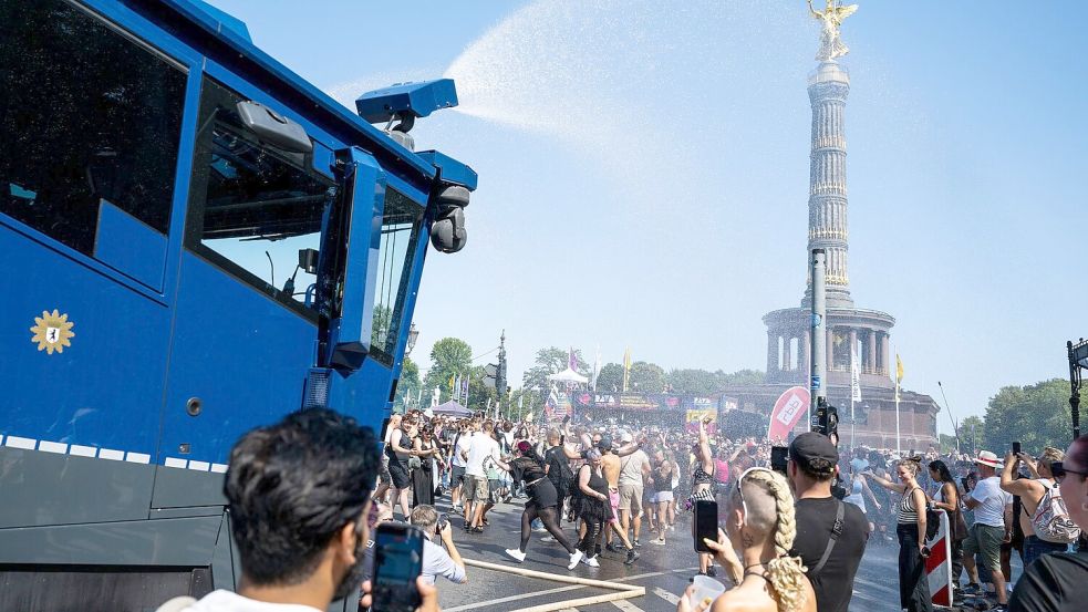 Ein Wasserwerfer der Polizei verschafft den Ravern etwas Abkühlung. Foto: Christophe Gateau