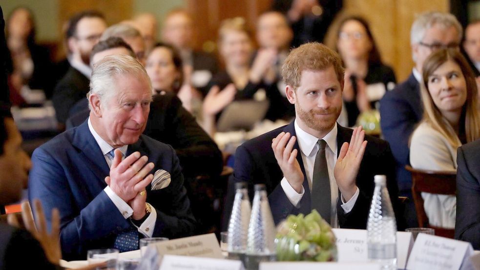 Ein Bild aus vergangenen Zeiten: Harry (r.) und sein Vater Charles, damals Prinz, an einem Tisch. (Archivbild) Foto: Matt Dunham/AP POOL/dpa