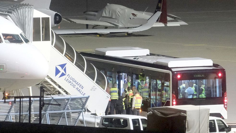 Mit einem Bus wurden die Männer zum Flugzeug gebracht. Foto: Sebastian Willnow/dpa