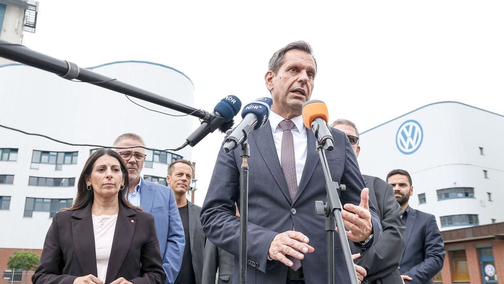 Nach einem Besuch des VW-Werks in Osnabrück gibt Olaf Lies (SPD, am Mikrofon), Ministerpräsident von Niedersachsen, ein Statement ab. Foto: David Ebener/dpa