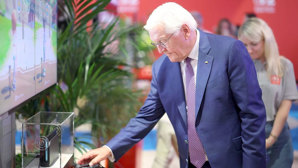 Steinmeier am Nintendo-Messestand, wo er digitales Bogenschießen als Sportart ausprobierte. Foto: Christoph Reichwein/dpa