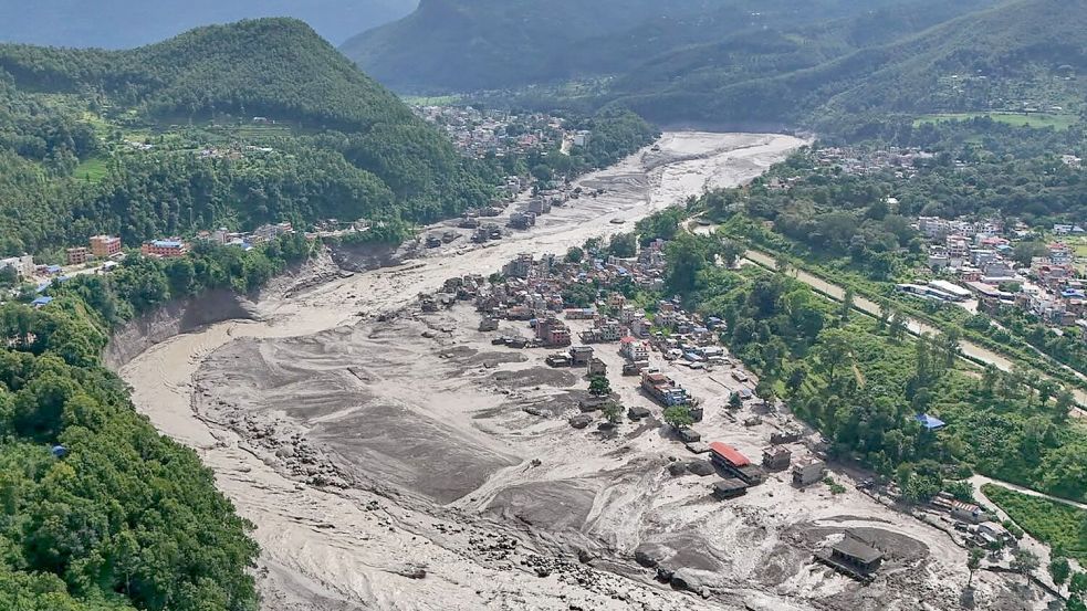Nach der Sturzflut in Nepal stehen beschädigte Häuser gefährlich nahe an den angeschwollenen Ufern des Trishuli-Flusses. Foto: Niranjan Shrestha/AP/dpa